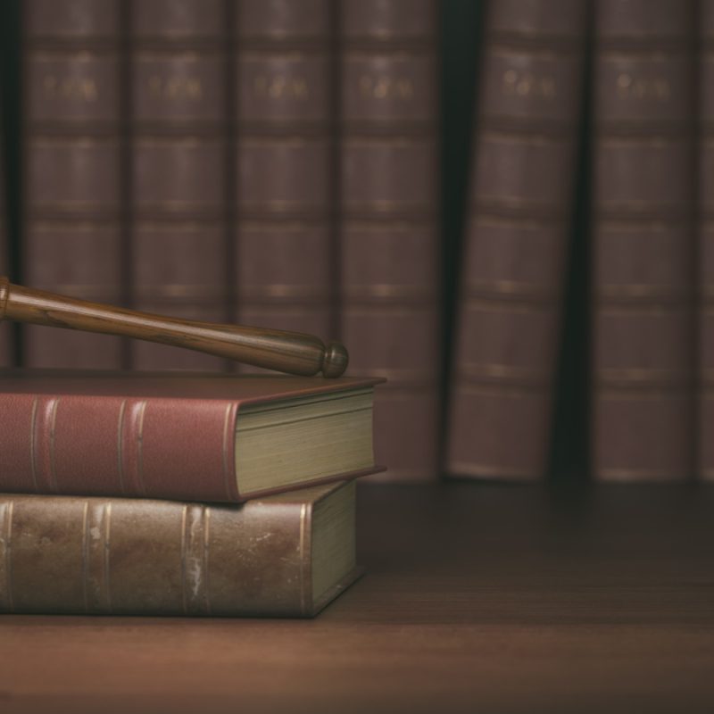 Gavel on the background of vintage lawyer books. Concept of law